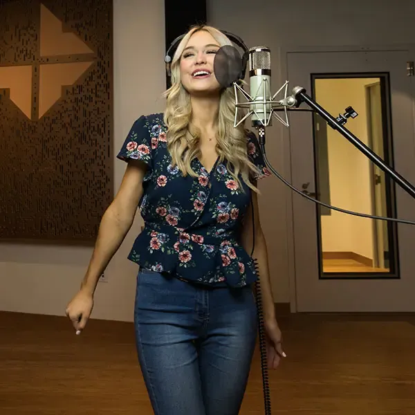 Female student singing in the recording studio